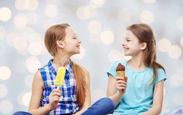 Happy little girls eating ice-cream over lights — Stock Photo, Image