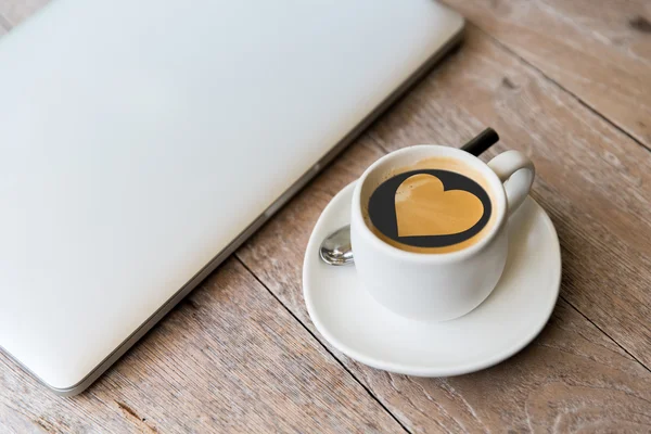 Primer plano de la computadora portátil y taza de café con forma de corazón —  Fotos de Stock