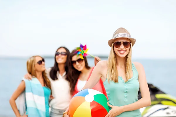 Девушка с мячом и друзьями на пляже — стоковое фото