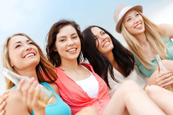 Meisjes met dranken op het strand — Stockfoto