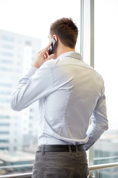 Businessman calling on smartphone in office — Stock Photo, Image