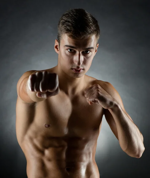 Young man on fighting stand over black background — Stock Photo, Image