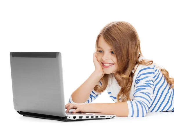 Menina estudante sorrindo com computador portátil deitado — Fotografia de Stock