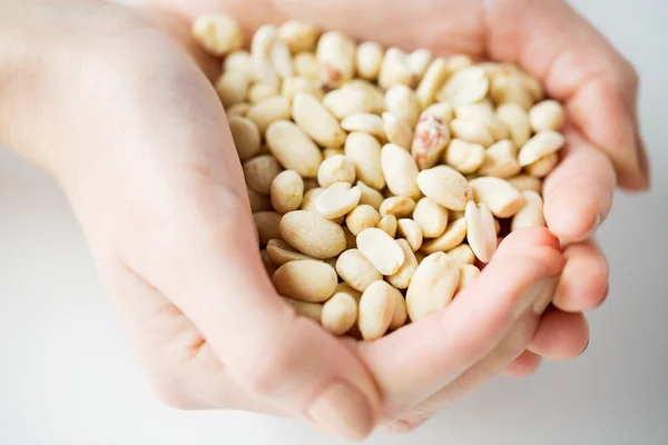 Gros plan des mains de la femme tenant des cacahuètes pelées — Photo