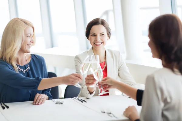 Happy women drinking champagne at restaurant — Stock Photo, Image