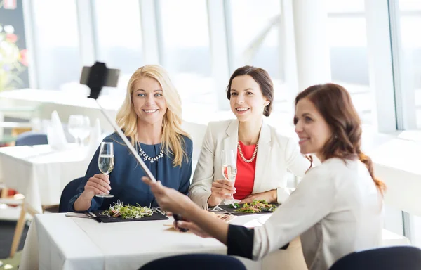 Women with smartphone taking selfie at restaurant — Stock Photo, Image