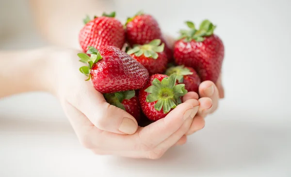 Primer plano de las manos de la mujer sosteniendo fresas — Foto de Stock