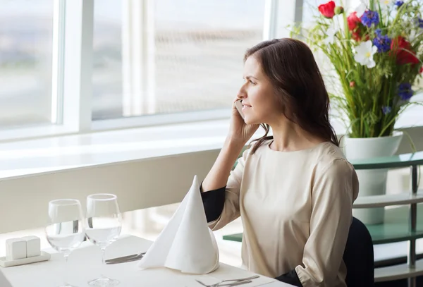 Mujer feliz llamando a un teléfono inteligente en el restaurante —  Fotos de Stock