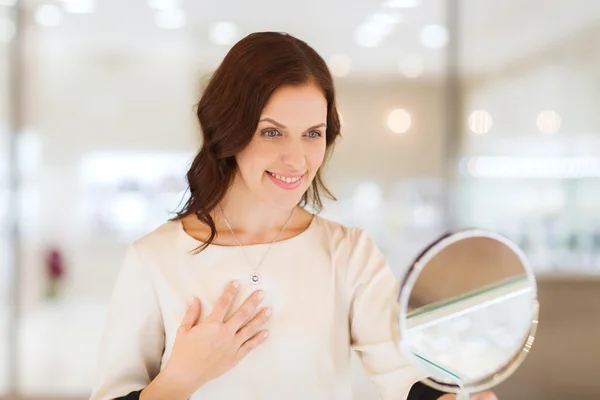 Щаслива жінка вибирає кулон в магазині ювелірних виробів — стокове фото