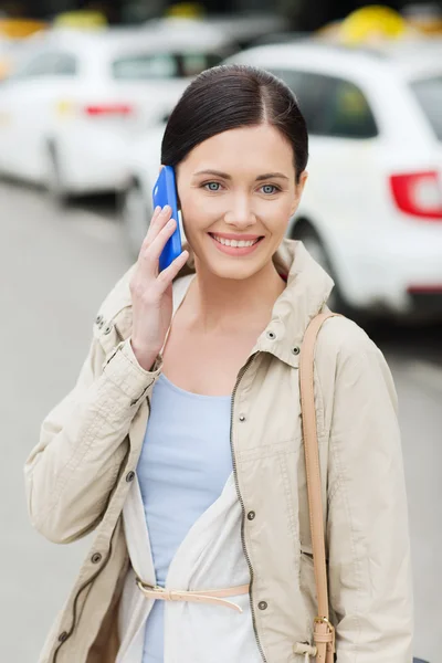 Donna sorridente con smartphone sopra il taxi in città — Foto Stock