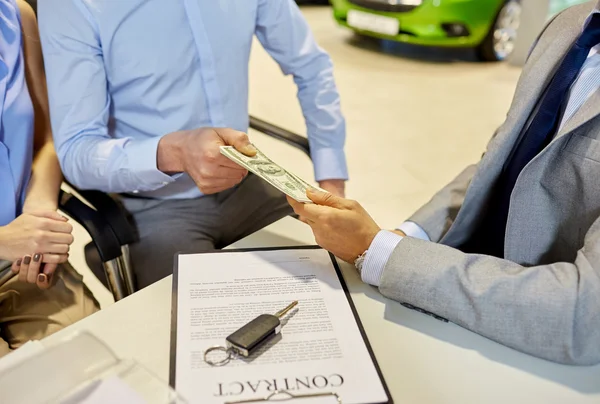 Zákazníci, dávat peníze na auto dealerů v salonu auto — Stock fotografie