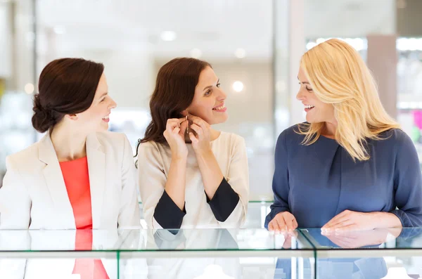 Glada kvinnor väljer Örhängen Smycken Store — Stockfoto