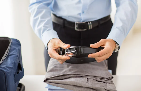 Businessman packing clothes into travel bag — Stock Photo, Image