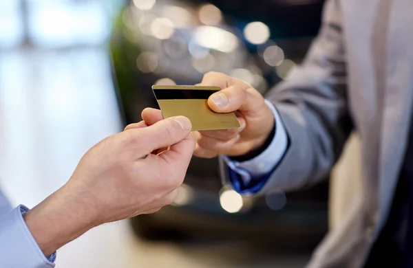 Customer giving credit card to car dealer in salon — Stock Photo, Image