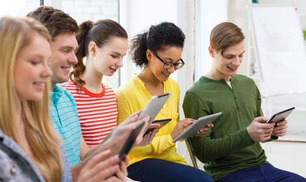 Estudantes sorridentes com tablet pc na escola — Fotografia de Stock