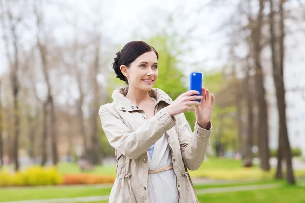 Mulher sorrindo tirar foto com smartphone — Fotografia de Stock