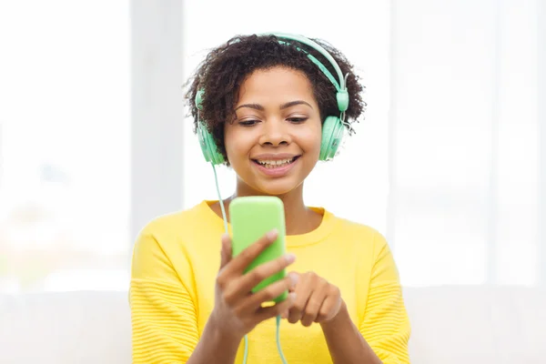 Femme africaine heureuse avec smartphone et écouteurs — Photo
