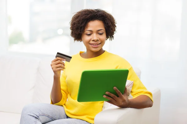 Glückliche Afrikanerin mit Tablet-PC und Kreditkarte — Stockfoto