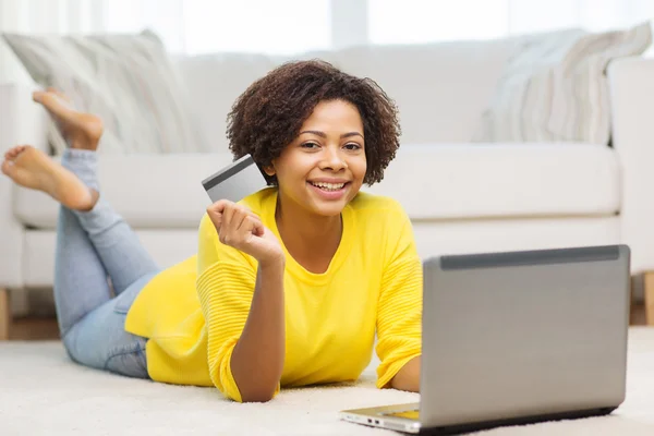 happy african woman with laptop and credit card