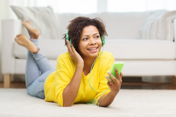 Happy african woman with smartphone and headphones — Stock Photo, Image