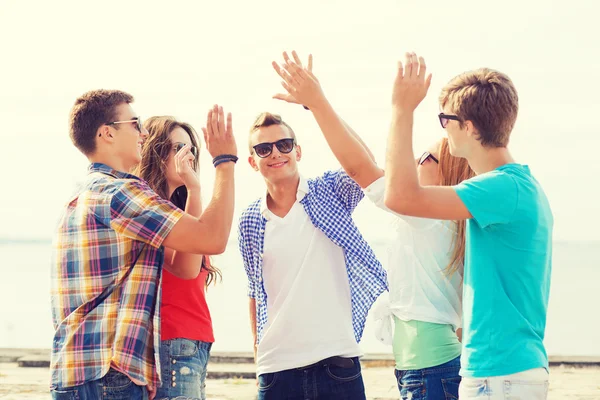 Gruppo di amici sorridenti fare cinque all'aperto — Foto Stock