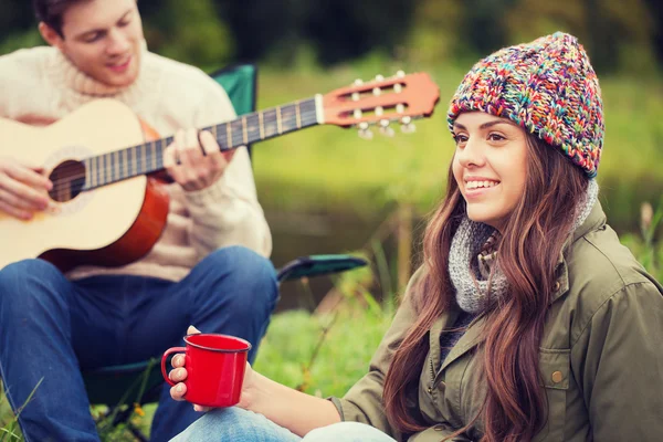 Sorrindo casal com guitarra no acampamento — Fotografia de Stock
