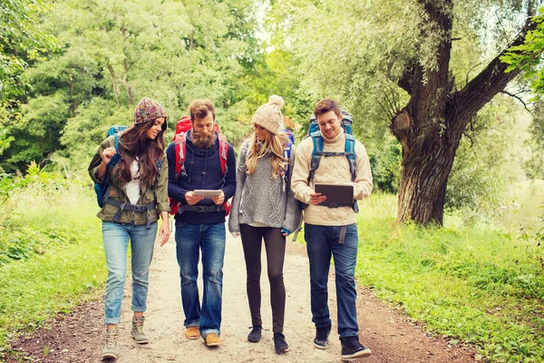 Grupo de amigos con mochilas y tableta pc — Foto de Stock