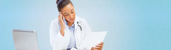 Vrouwelijke arts met laptop pc op zoek op papier — Stockfoto