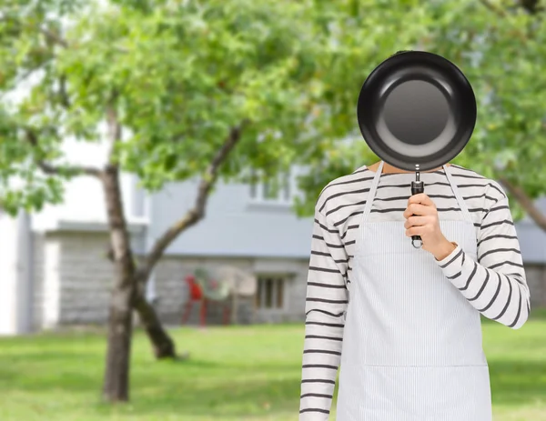 Man of cook in schort gezicht achter koekenpan verbergen — Stockfoto