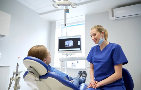 Dentista mujer feliz con chica paciente en la clínica —  Fotos de Stock