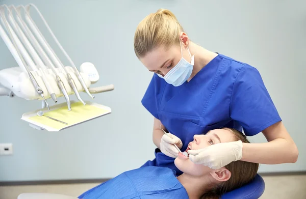 Dentista feminino verificando os dentes da menina paciente — Fotografia de Stock