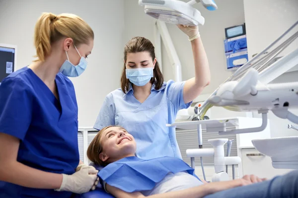 Dentista mujer feliz con chica paciente en la clínica —  Fotos de Stock