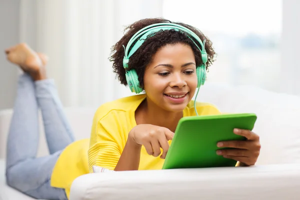 Mujer africana feliz con la PC tableta y auriculares — Foto de Stock