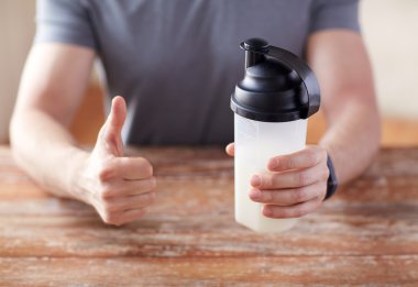 man with protein shake bottle showing thumbs up clipart