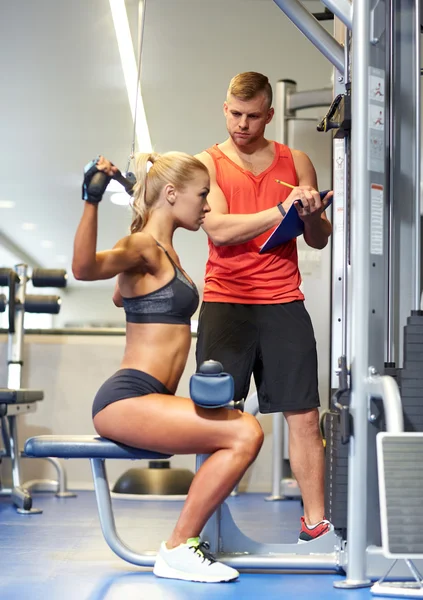 Muž a žena, protahuje svaly na posilovnu stroji — Stock fotografie