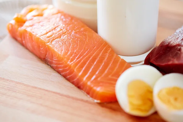 Close up de filetes de salmão, ovos e leite na mesa — Fotografia de Stock