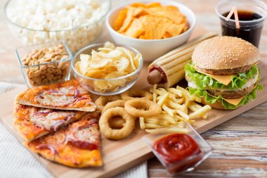 close up of fast food snacks and drink on table clipart