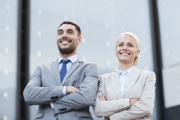 Hommes d'affaires souriants debout au-dessus de l'immeuble de bureaux — Photo