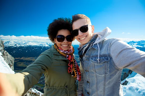 Feliz casal adolescente tomando selfie sobre montanhas — Fotografia de Stock