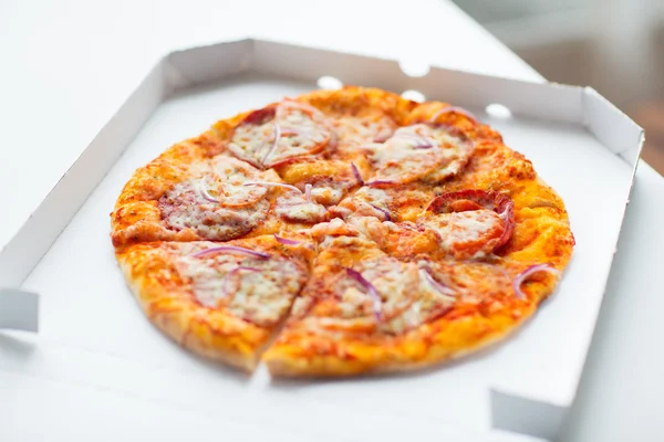 Close up of pizza in paper box on table — Stock Photo, Image