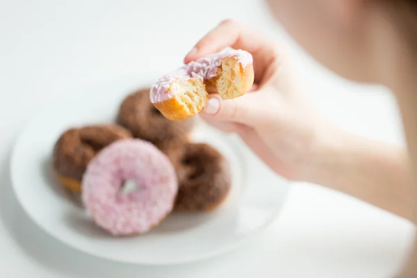 Närbild på handen håller bitten glaserade donut — Stockfoto