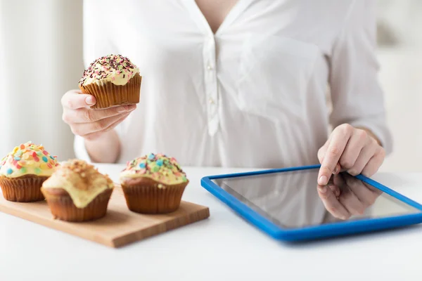 Close up of woman with cupcakes and tablet pc — Stock Photo, Image