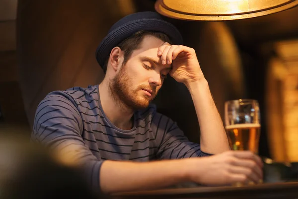 Unhappy lonely man drinking beer at bar or pub — Stock Photo, Image