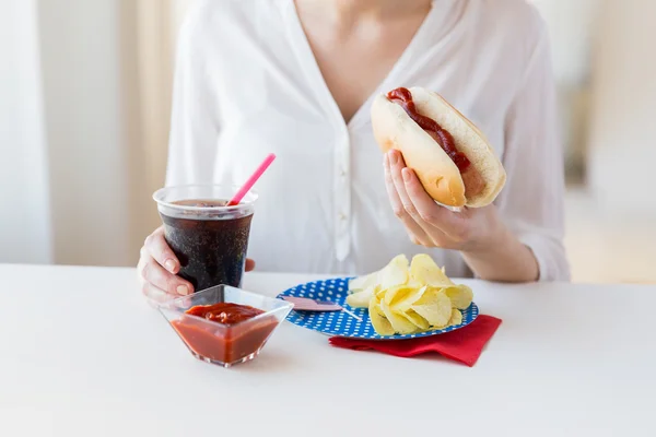 Primer plano de la mujer comiendo perrito caliente con cola de coca — Foto de Stock