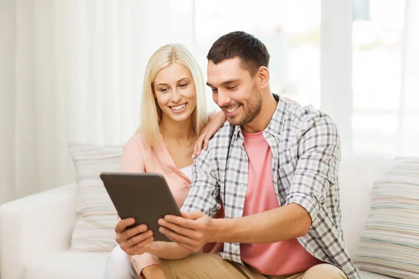 Sorrindo casal feliz com tablet pc em casa — Fotografia de Stock