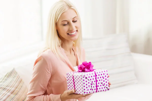 Lächelnde Frau mit Geschenkbox zu Hause — Stockfoto