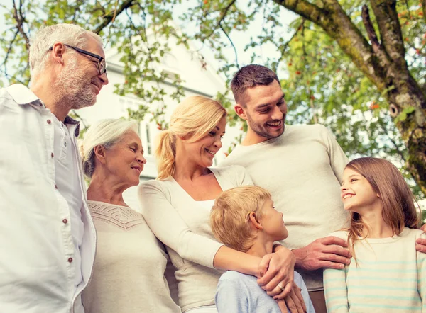 Familia feliz en frente de la casa al aire libre —  Fotos de Stock