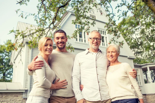 Família feliz na frente da casa ao ar livre — Fotografia de Stock