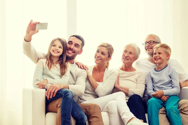 Šťastná rodina s chytrým telefonem doma — Stock fotografie