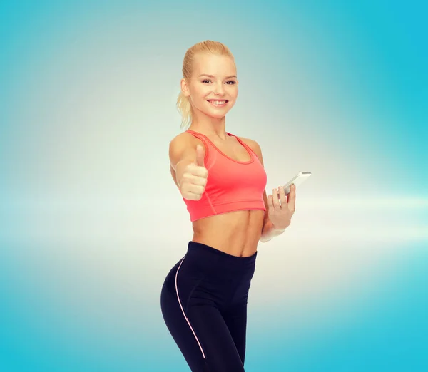 Mujer deportiva sonriente con teléfono inteligente — Foto de Stock